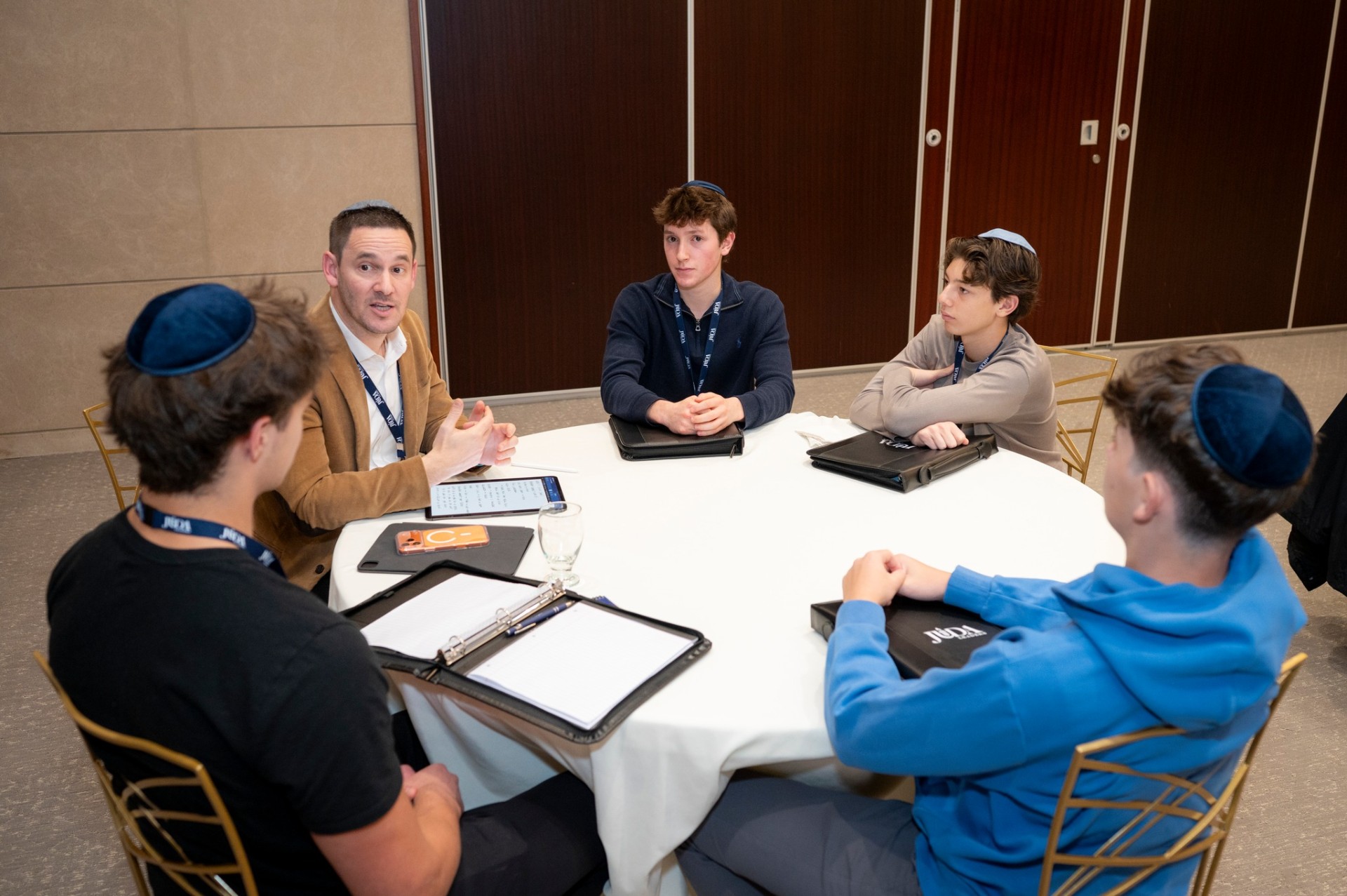 Mentor in conversation with JUDA students around a table